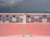 a black and white photo of a white building and a red and gray wall with different patterns