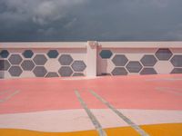 a black and white photo of a white building and a red and gray wall with different patterns