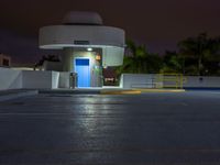 the entrance to an empty parking lot at night with no one visible yet in the dark