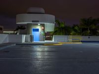 the entrance to an empty parking lot at night with no one visible yet in the dark