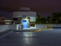 the entrance to an empty parking lot at night with no one visible yet in the dark