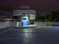 the entrance to an empty parking lot at night with no one visible yet in the dark