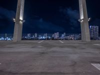 an open parking lot with a large skyline in the back ground and two columns at the bottom