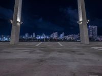 an open parking lot with a large skyline in the back ground and two columns at the bottom