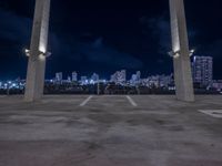 an open parking lot with a large skyline in the back ground and two columns at the bottom