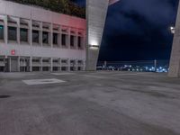 a tall building with lights sitting on top of it at night time in the parking lot