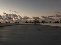 the sun is setting over a parking lot with no cars in it for use by pedestrians and other vehicles