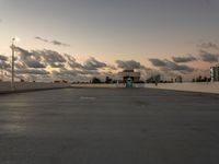 the sun is setting over a parking lot with no cars in it for use by pedestrians and other vehicles