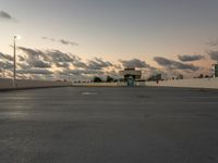 the sun is setting over a parking lot with no cars in it for use by pedestrians and other vehicles