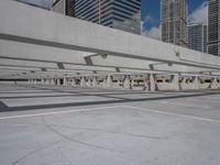 an empty parking lot surrounded by tall buildings and tall glass skyscrapers in the background