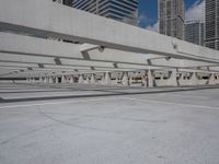 an empty parking lot surrounded by tall buildings and tall glass skyscrapers in the background