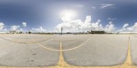 a fisheye photograph shows yellow lines in a parking lot on the outskirts of town