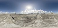 a wide angle panoramic view of the desert, with the sun in the background