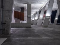 a parking garage is lined with cement columns and a skateboard on the sidewalk near by