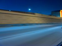 a large truck moving down the highway near a traffic light at night with a long exposure lens