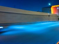 a large truck moving down the highway near a traffic light at night with a long exposure lens