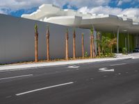 there is a modern building with palm trees on the side of the road with the numbers one on each side of it