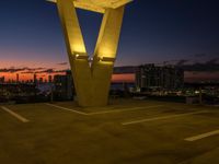 the large letter v stands on top of a parking lot at dusk with a dark sky in the background