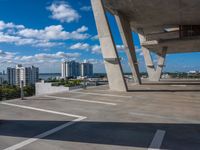 a skate board in a parking lot in front of tall buildings with a sky background