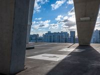 a concrete structure sitting on top of a parking lot under a blue sky with a few clouds