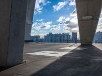 a concrete structure sitting on top of a parking lot under a blue sky with a few clouds