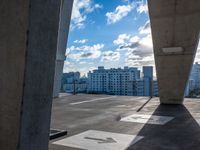 a concrete structure sitting on top of a parking lot under a blue sky with a few clouds