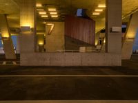 a parking garage filled with lots of cement pillars and windows at dusk with neon lights