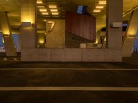 a parking garage filled with lots of cement pillars and windows at dusk with neon lights