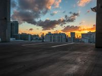 the sun sets over the horizon over a large cityscape with buildings and towers