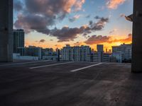 the sun sets over the horizon over a large cityscape with buildings and towers