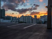 the sun sets over the horizon over a large cityscape with buildings and towers