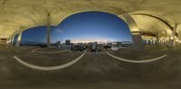 a photo of a circular view of a city from inside of a skate park in the evening