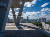 a balcony overlooking the city of buildings in a sunny day with blue skies and clouds