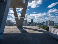 a balcony overlooking the city of buildings in a sunny day with blue skies and clouds