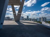 a balcony overlooking the city of buildings in a sunny day with blue skies and clouds