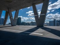 a skateboarder is performing tricks in a cement city parking garage on a sunny day