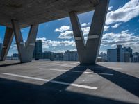 a skateboarder is performing tricks in a cement city parking garage on a sunny day