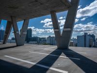 a skateboarder is performing tricks in a cement city parking garage on a sunny day