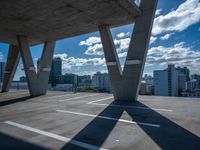 a skateboarder is performing tricks in a cement city parking garage on a sunny day