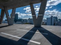 a skateboarder is performing tricks in a cement city parking garage on a sunny day