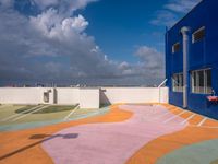 the courtyard of an empty building in the daytime light with clouds in the sky above