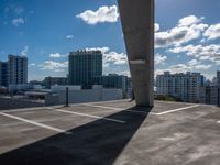 an open air parking lot and skyline view in front of buildings and sky high rise condo buildings