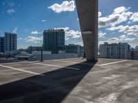 an open air parking lot and skyline view in front of buildings and sky high rise condo buildings