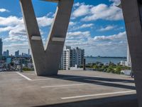 the view over buildings from the top of a bridge that crosses the city street in the distance