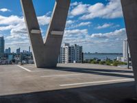 the view over buildings from the top of a bridge that crosses the city street in the distance