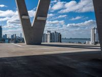 the view over buildings from the top of a bridge that crosses the city street in the distance