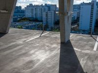 a skateboarder rides down an empty cement street near buildings in an urban area