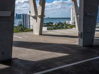 a photo looking out onto the water in an empty parking lot next to a concrete pier