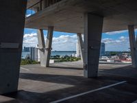 a photo looking out onto the water in an empty parking lot next to a concrete pier