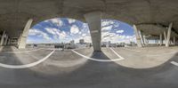 a fish eye lens view of a street with empty benches below it with a blue sky